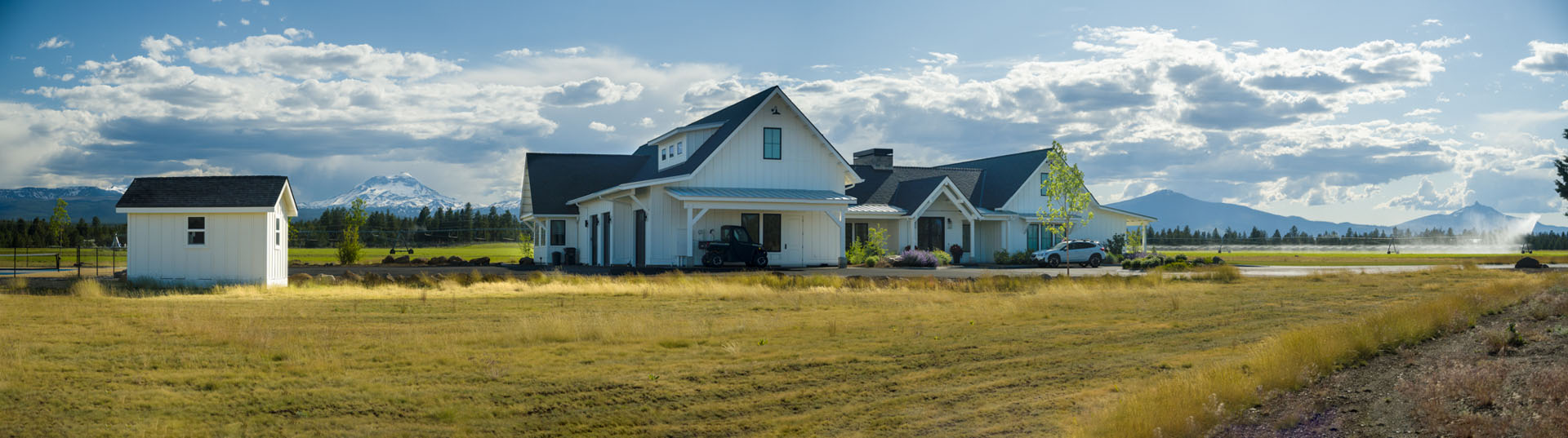 Green fields with blue skies with a white residential farmhouse