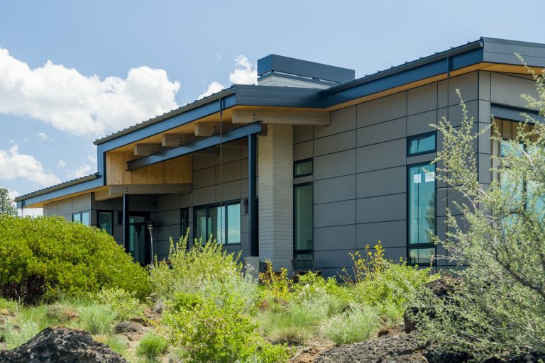 Outside view of contemporary ranch home with green shrubbery